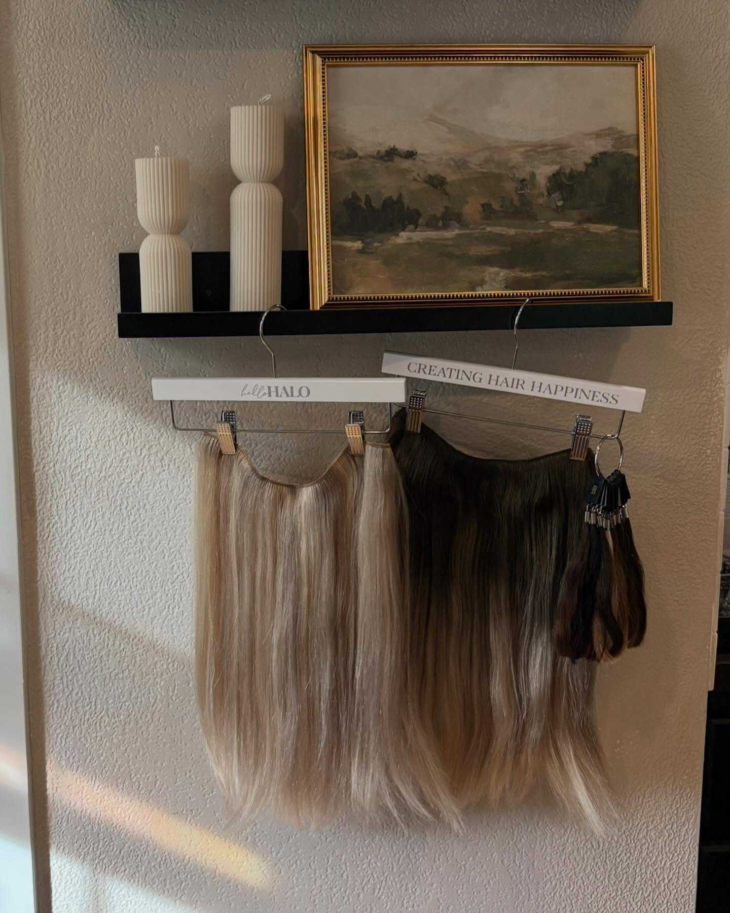 Hair extensions displayed below candles and a landscape painting.